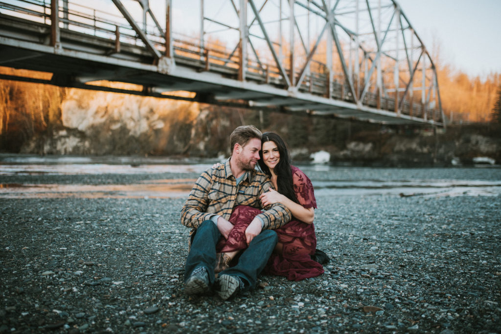 A couple sitting under a bridge in Alaska