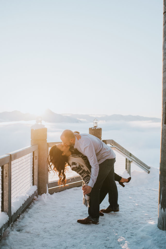 Couple dip kissing in the sunset after surprise proposal at Alyeska resort