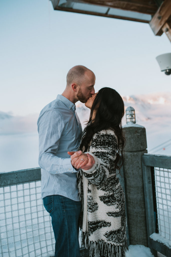 Couple kissing for engagement photos up in mountains