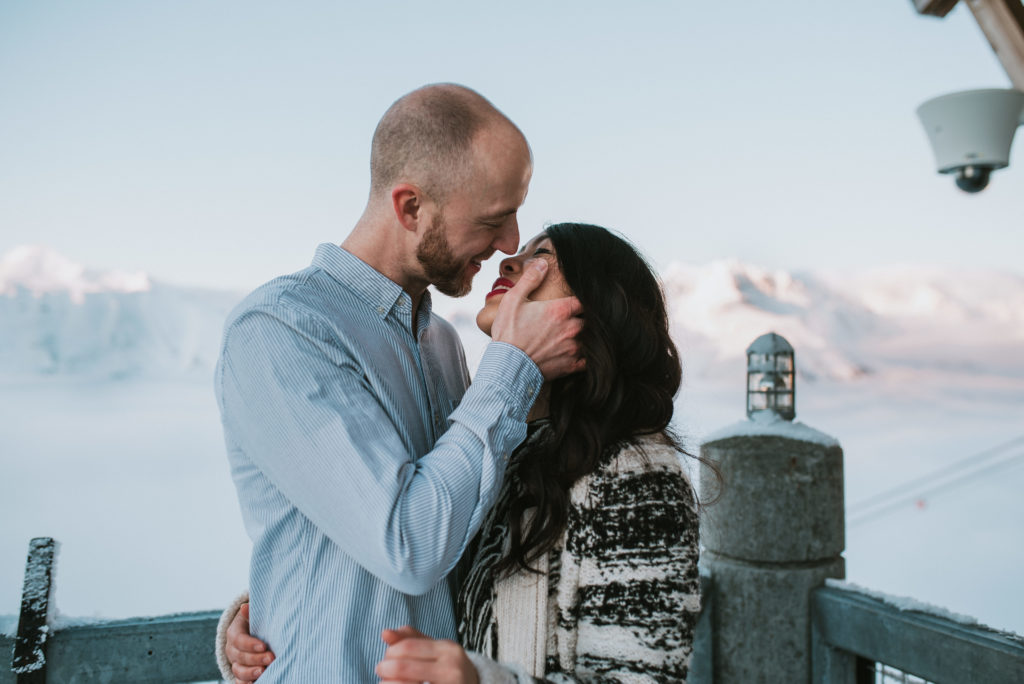 Couple kissing for engagement photos up in mountains