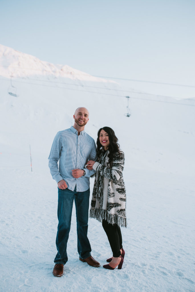 Couple smiling at the camera after surprise proposal at Alyeska Reosrt