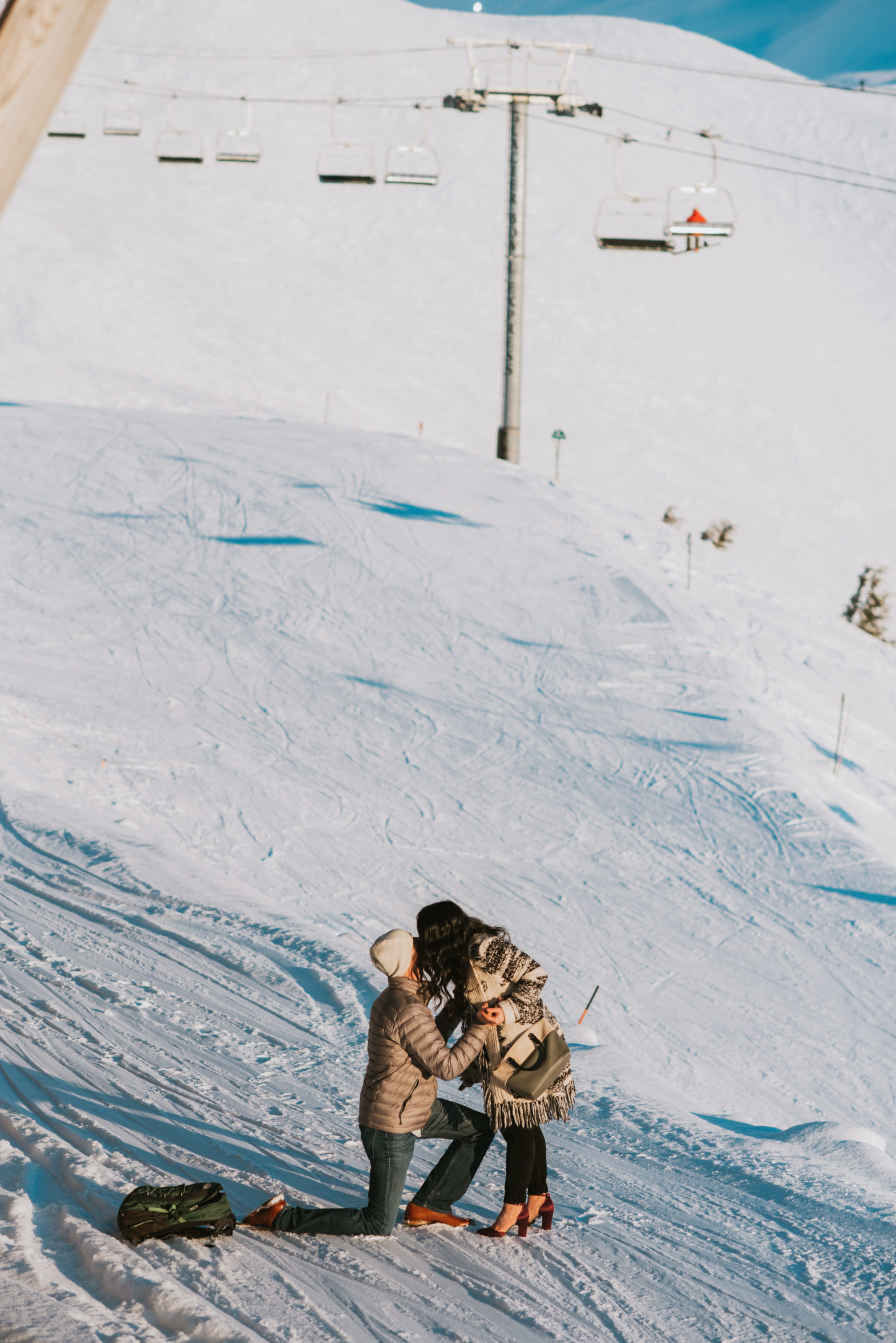 A man proposing to his girlfriend on the top of snow mountainside at alyeska resort, she said yes