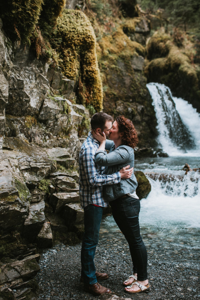 couple kissing at base of waterfall