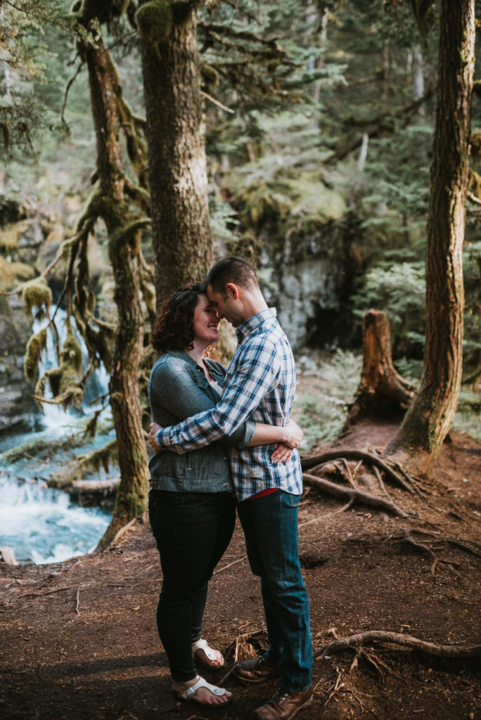 couple kissing in woods in girdwood alaska during engagement session