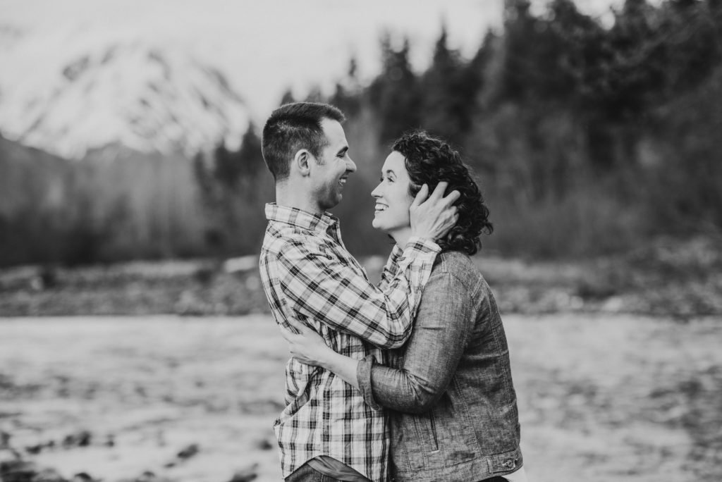 couple laughing and smiling during engagement session in black and white photo