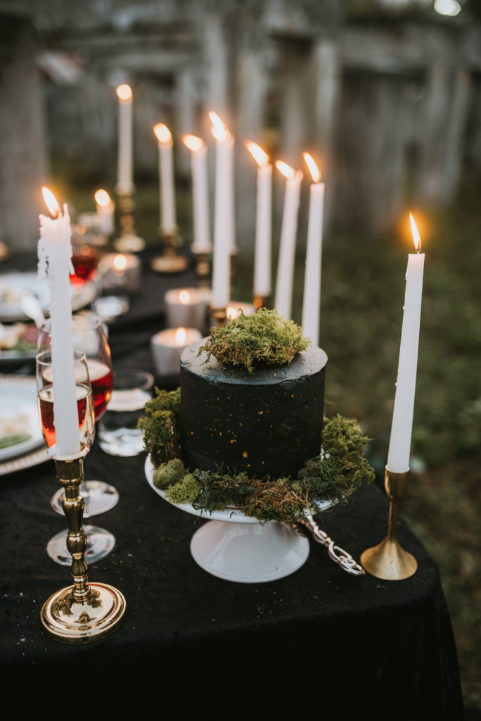 Gorgeous gold splatter cake with moss and candelight