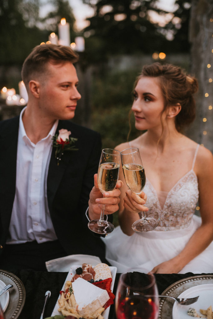 Couple cheersing champagne glasses at candlelit table