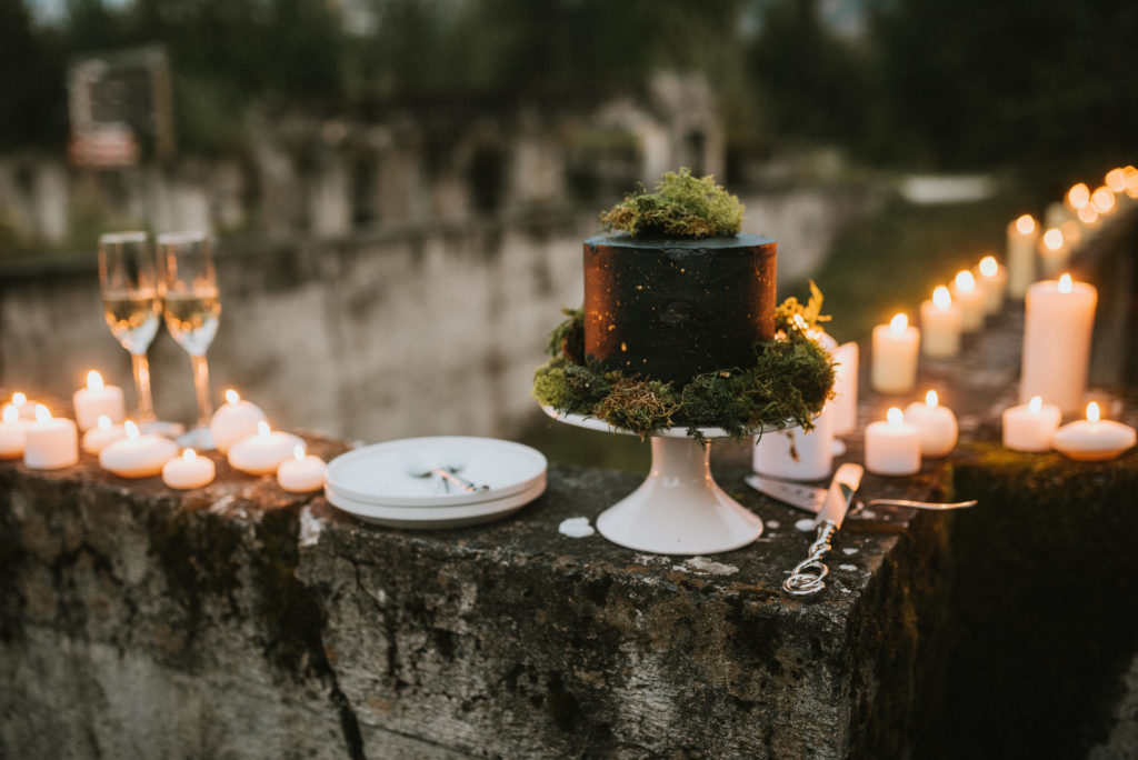Gorgeous black and grey cake with gold splatter and moss