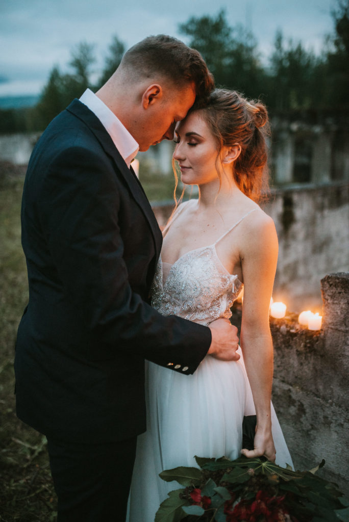 Bride and groom forehead to forehead in the candle light