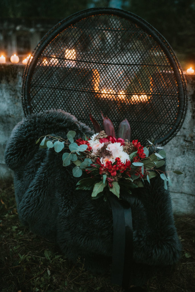 Beautiful wild red and white bouquet on black wicker chair and black sheepskin rug