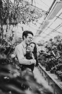 Couple laughing and smiling in greenhouse