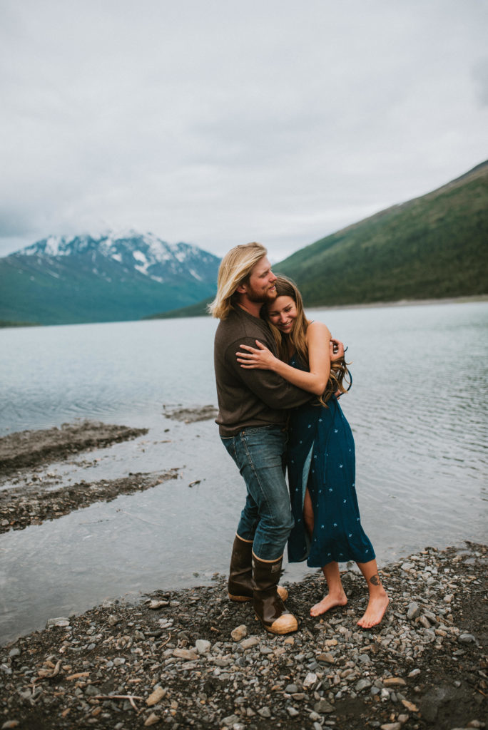 Couple hugging and laughing on shore of Eklutna Lake