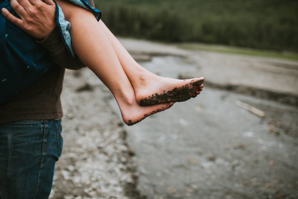 Detail photo of feet covered in sand from lake shore