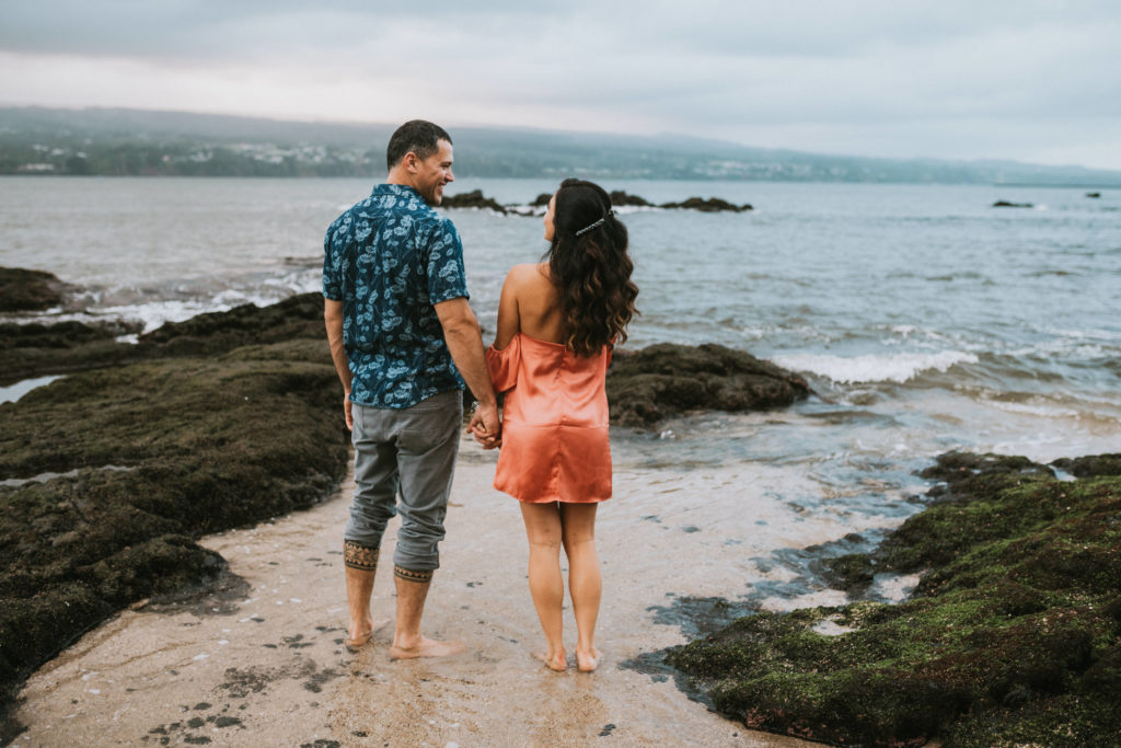 Couple holding hands and walking into the water
