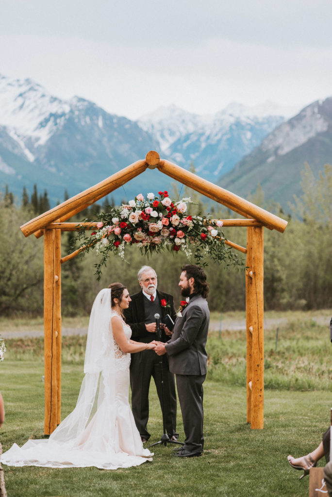 Mountain backdrop of ceremony and bride and groom holding hands
