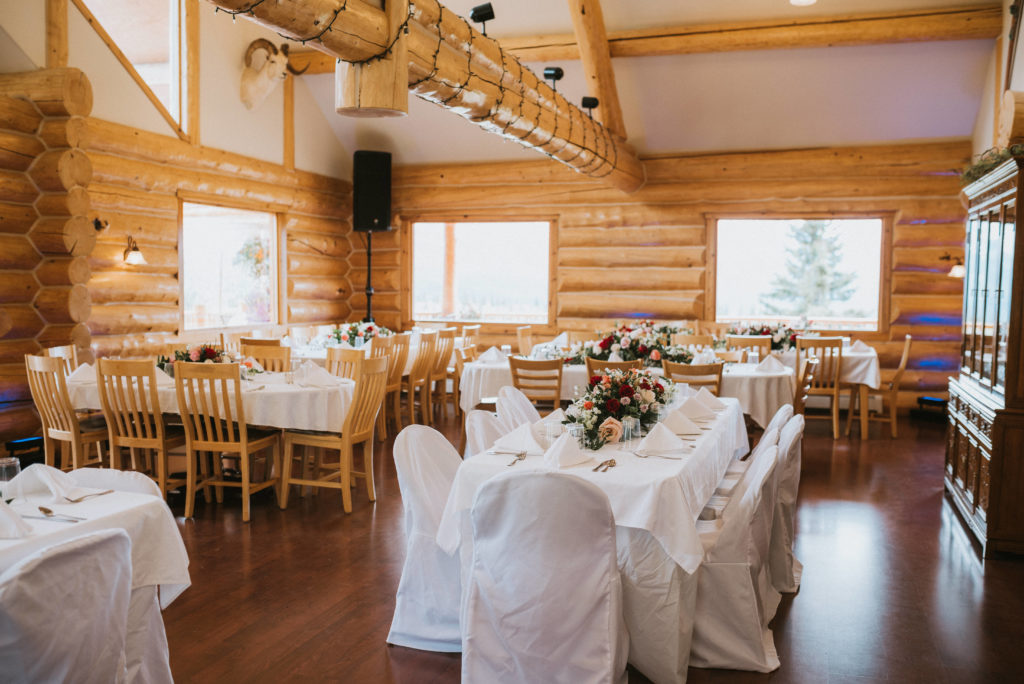 inside majestic valley lodge venue, white tables, flowers, log cabin