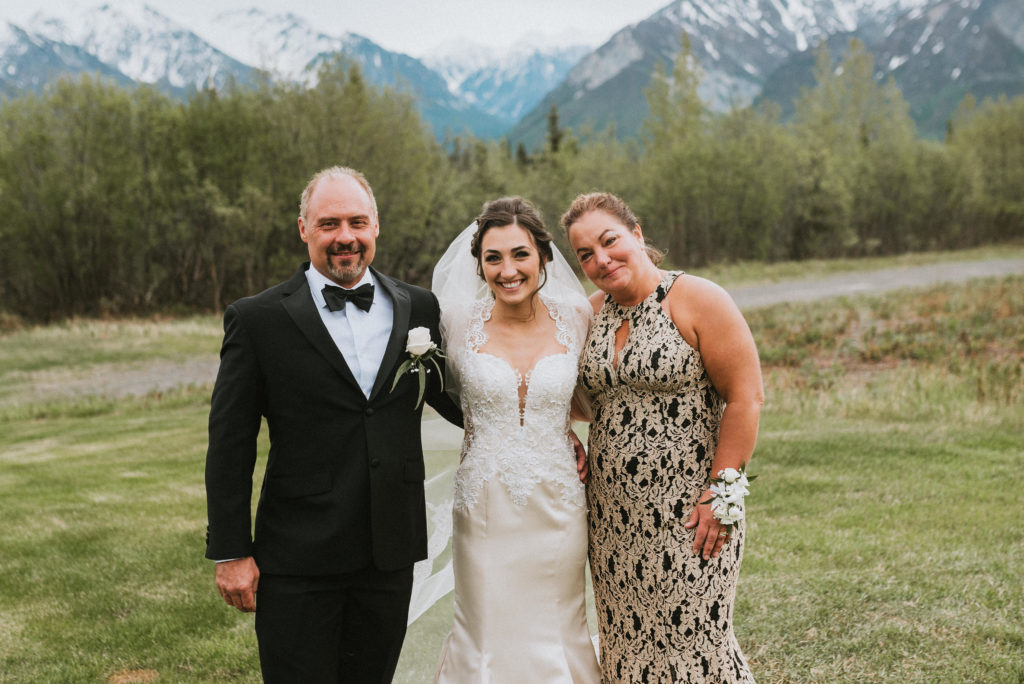 Bride with both parents mountain back drop
