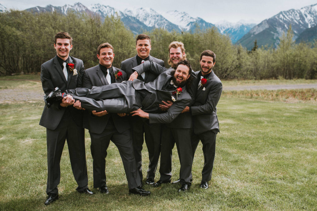 groomsmen in grey tuxes with mountain back drop
