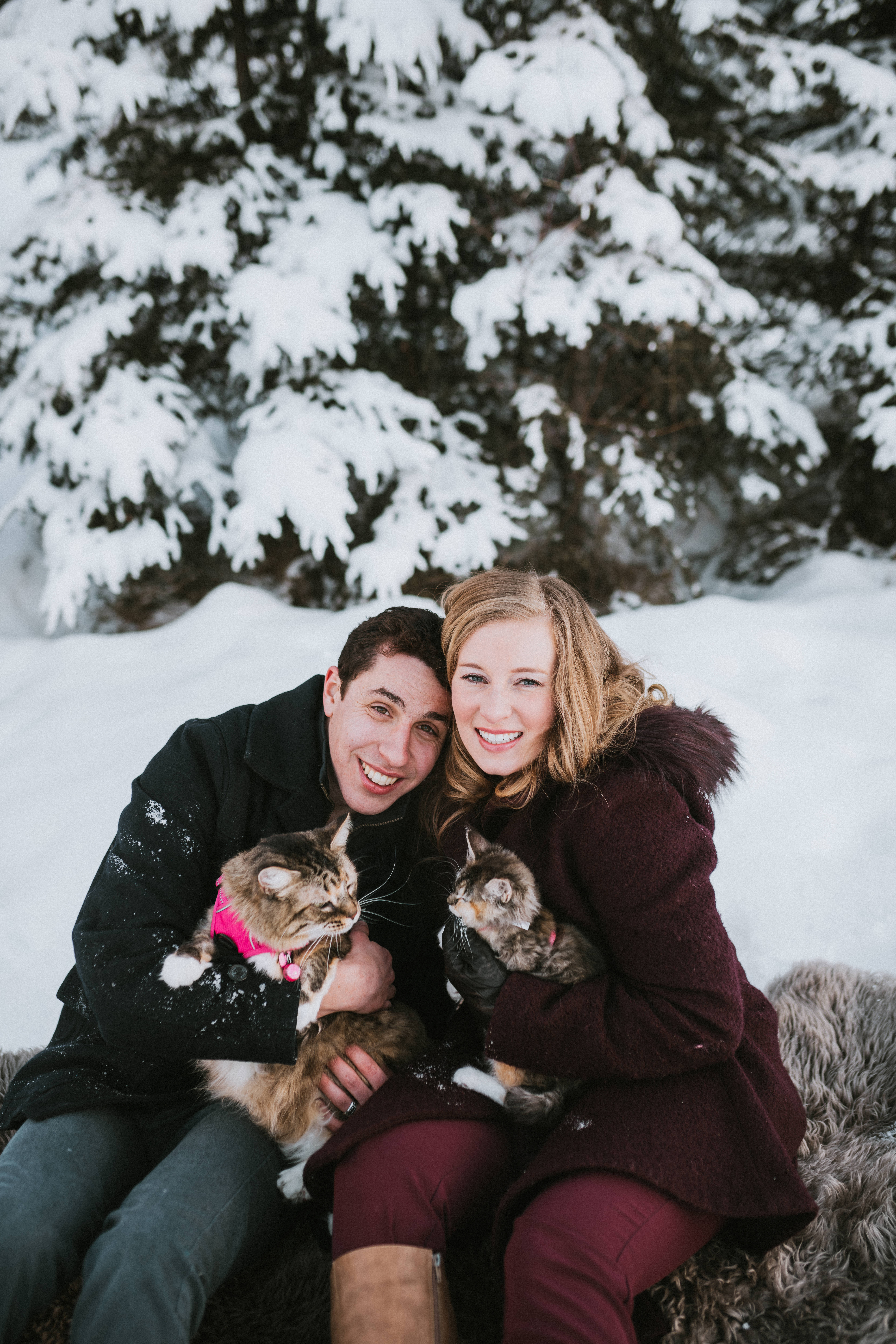 Couple smiling at camera with their two cats