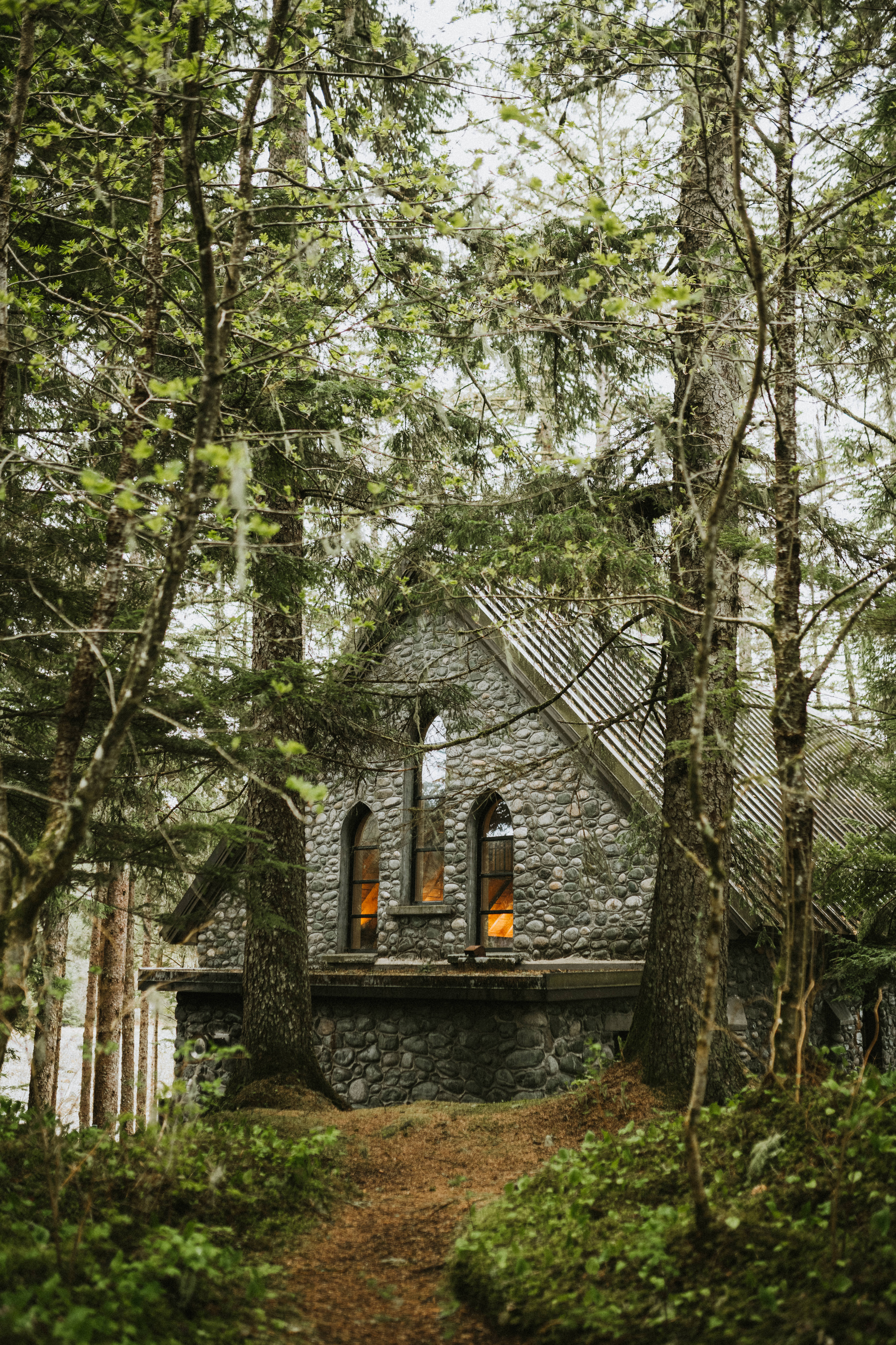 Stone chapel in lush green forest of Juneau, Alaska.