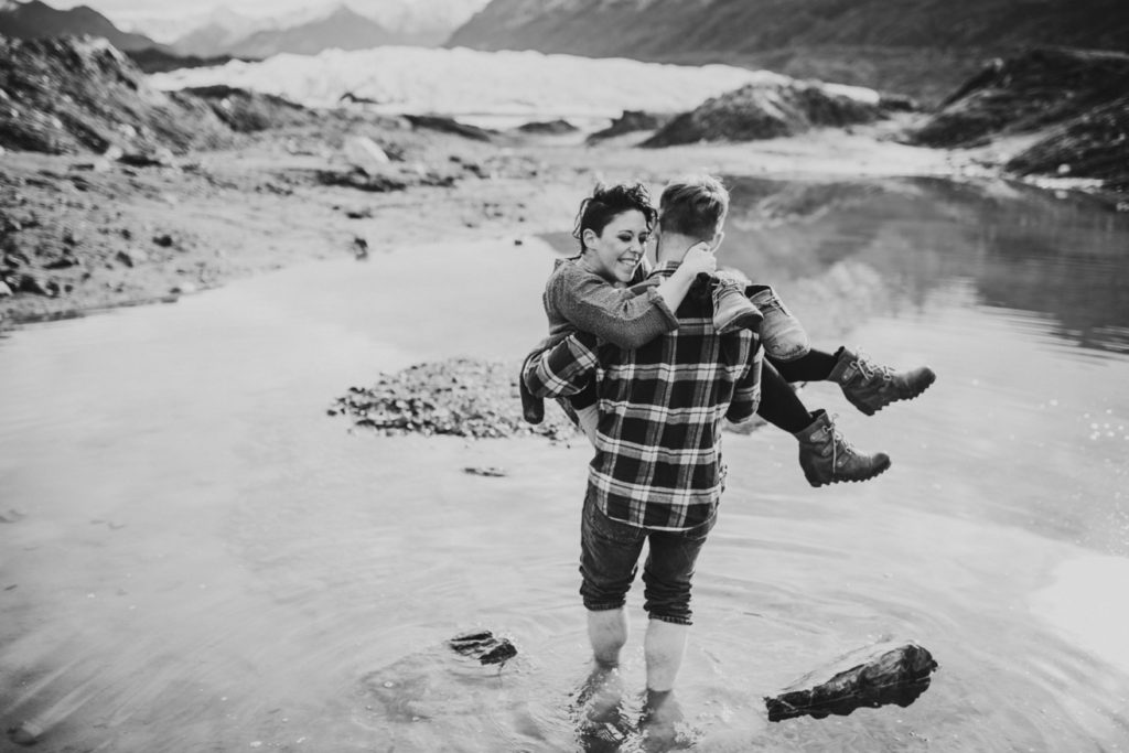 Cute photo of couple where he picked her up to carry across a glacier lake.