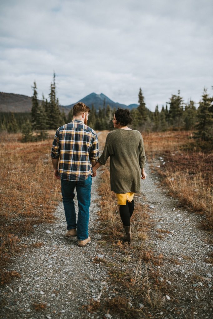 Couple walking down pathway of all foliage in Alaska