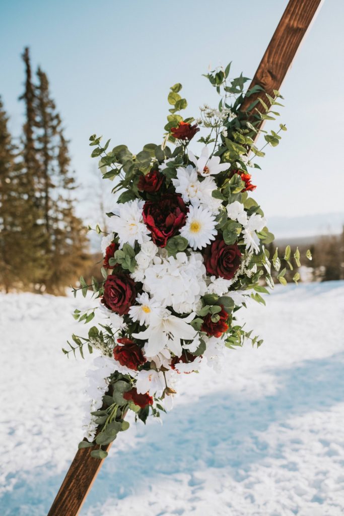 Flower details on triangle arch at Alaska winter wedding