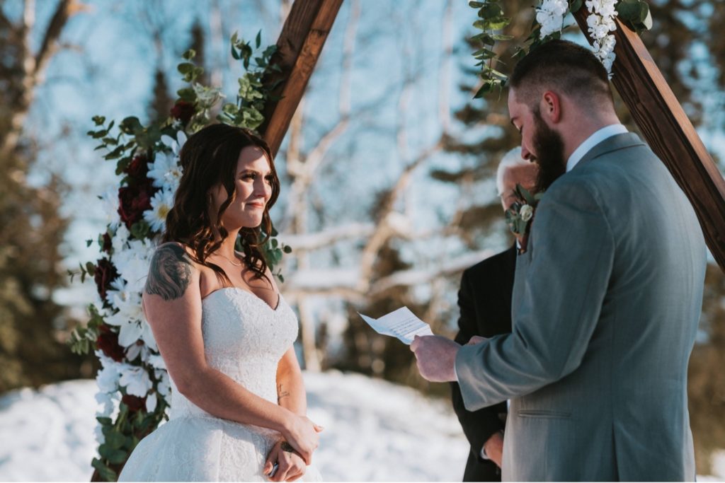 Bride crying during vow reading at Alaska winter wedding