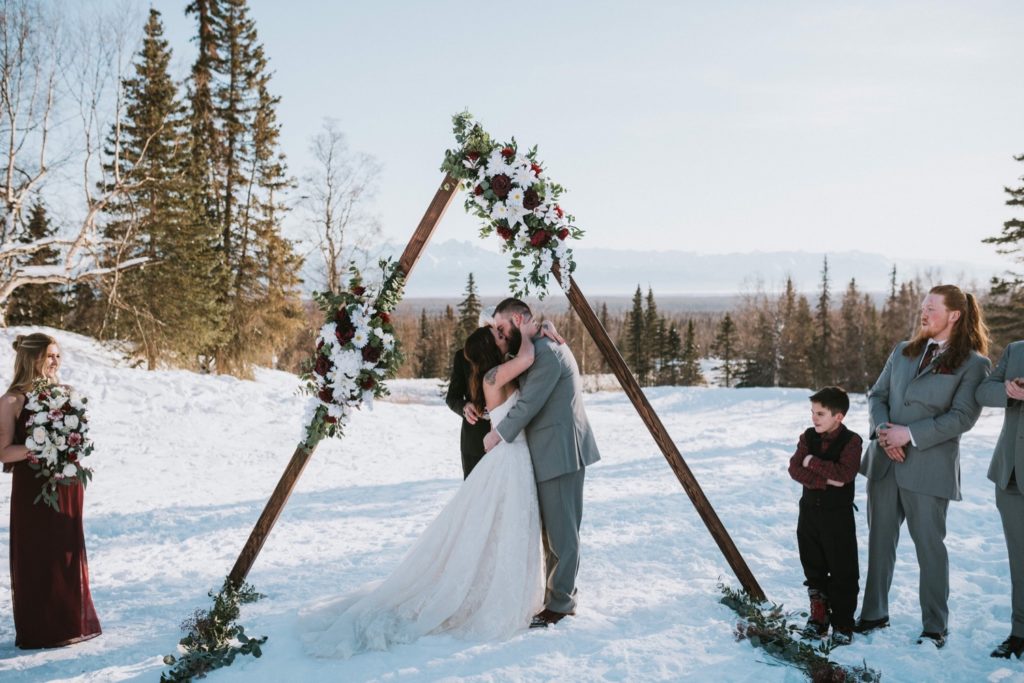 Bride and grooms first kiss during winter ceremony