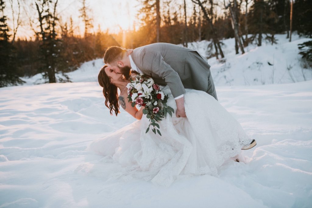 Alaska winter wedding dip kiss