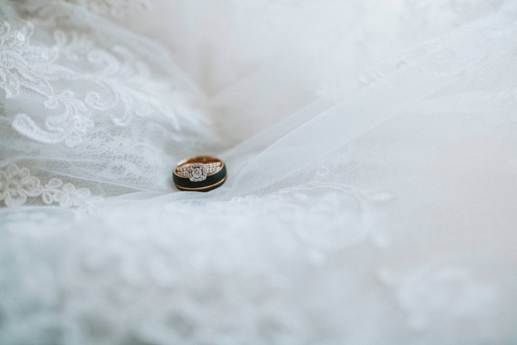 Wedding rings sitting on wedding dress
