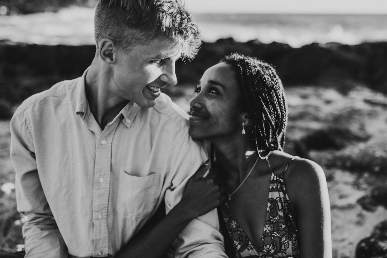 black and white photo of a couple leaning on each other smiling up at one another