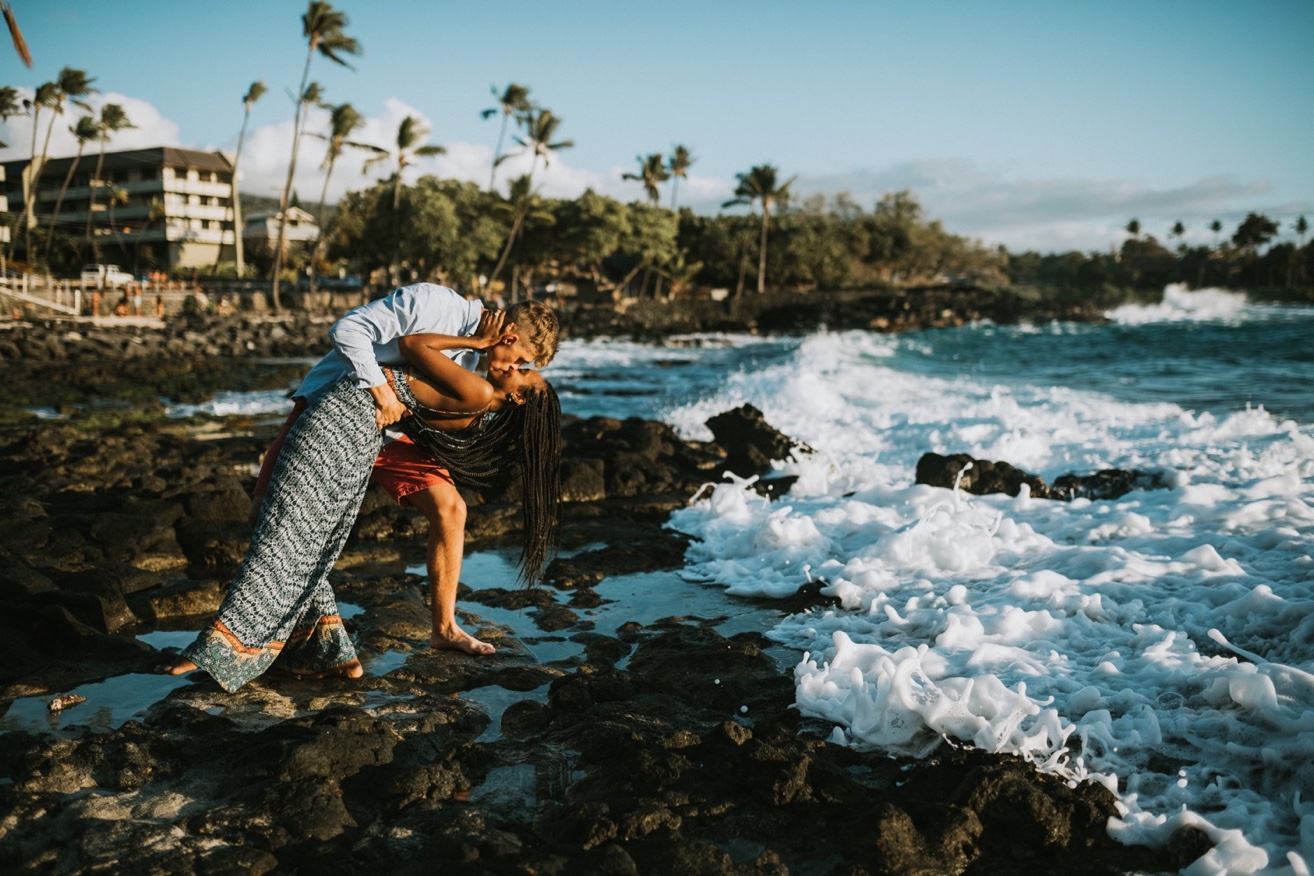 Couple dip kissing romantically on the beach during photoshoot with a kona photographer