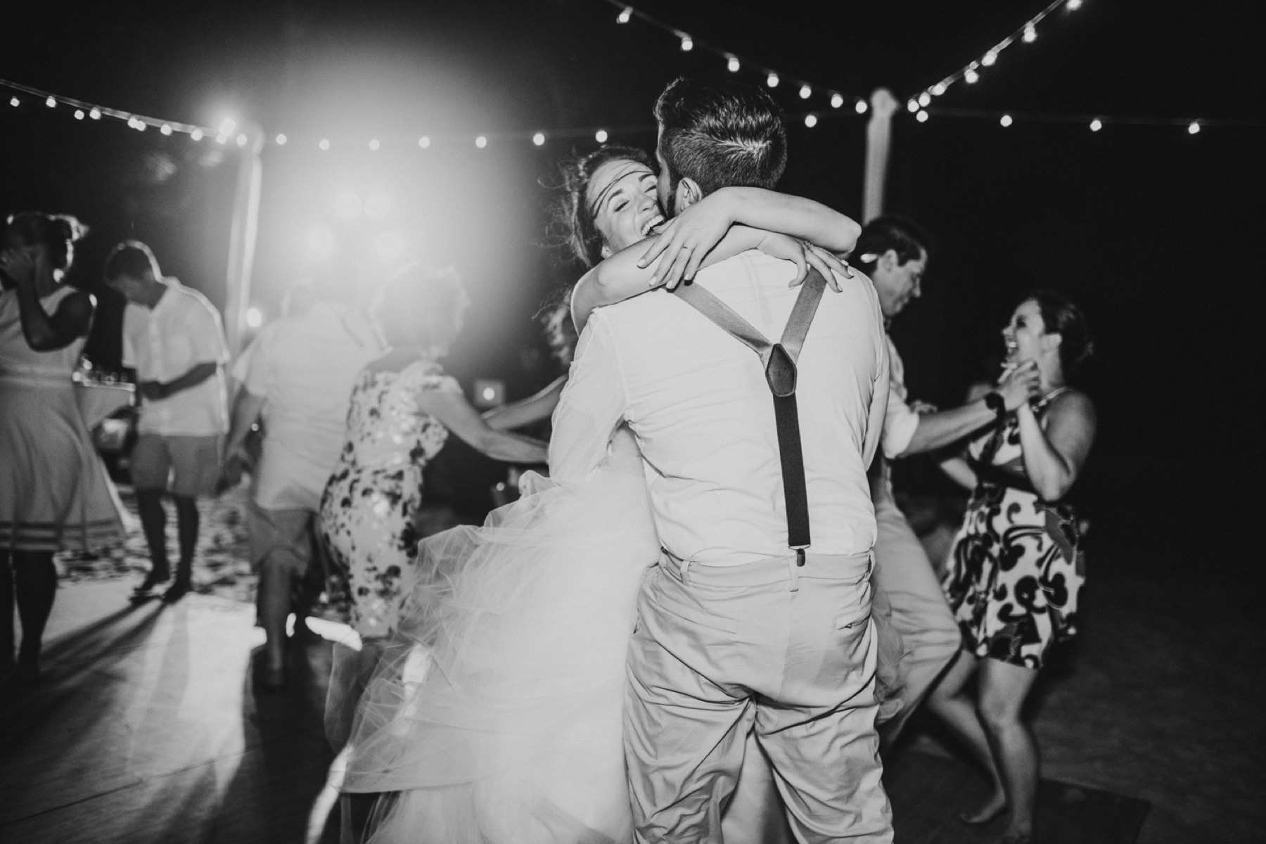 Black and white photo of Bride and groom laughing and dancing during their reception