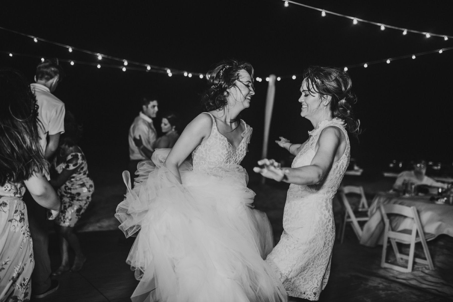 Black and white photo of bride and mother dancing at wedding