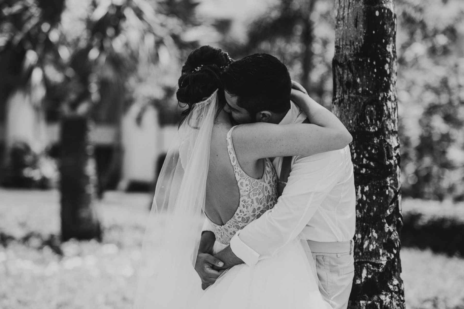 Black and white photo of couple hugging in gardens
