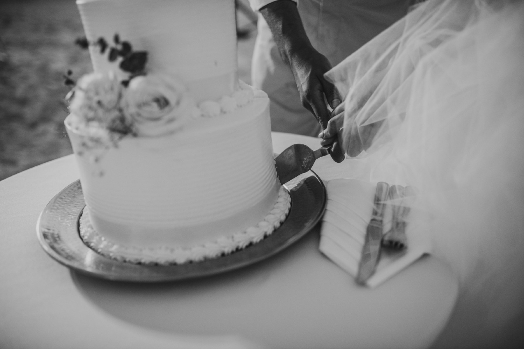 Black and white photo of the bride and groom cutting their cake