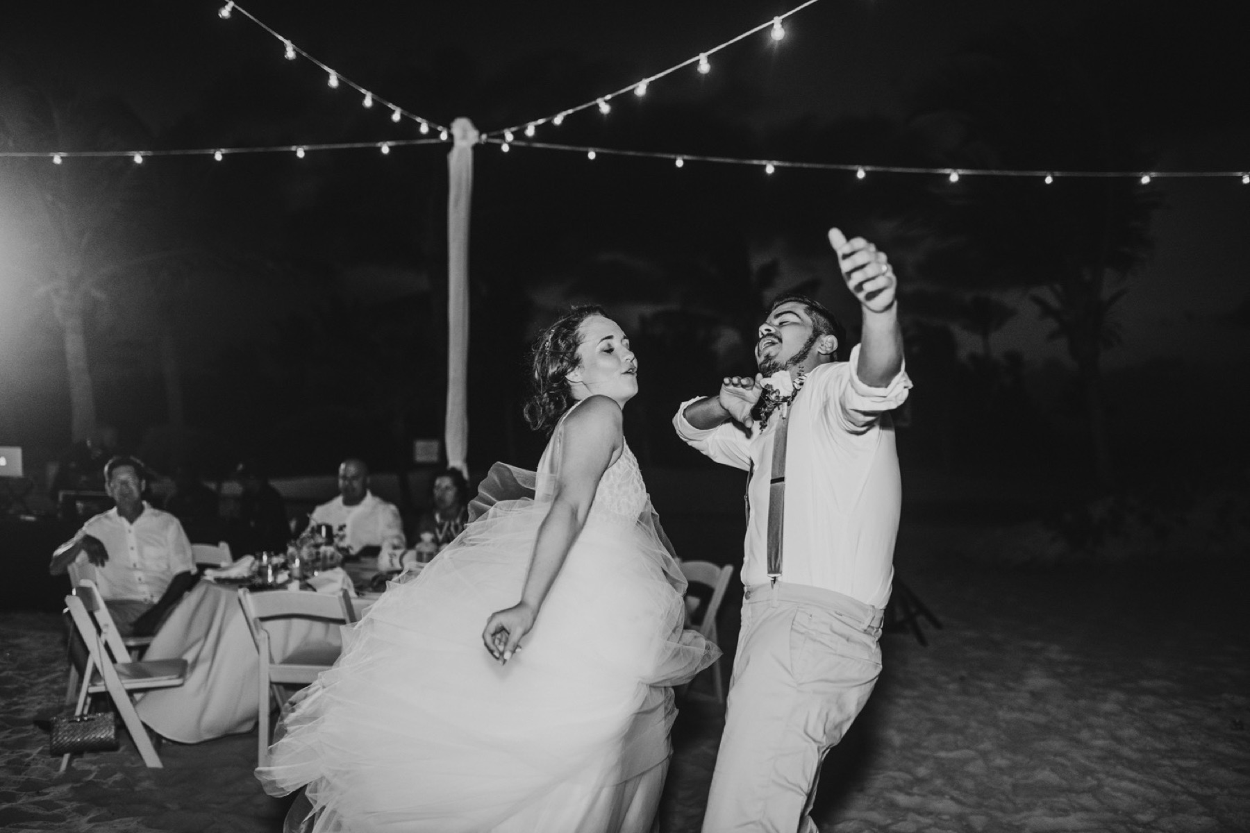 Black and white photo of bride and groom getting their groove on at their wedding