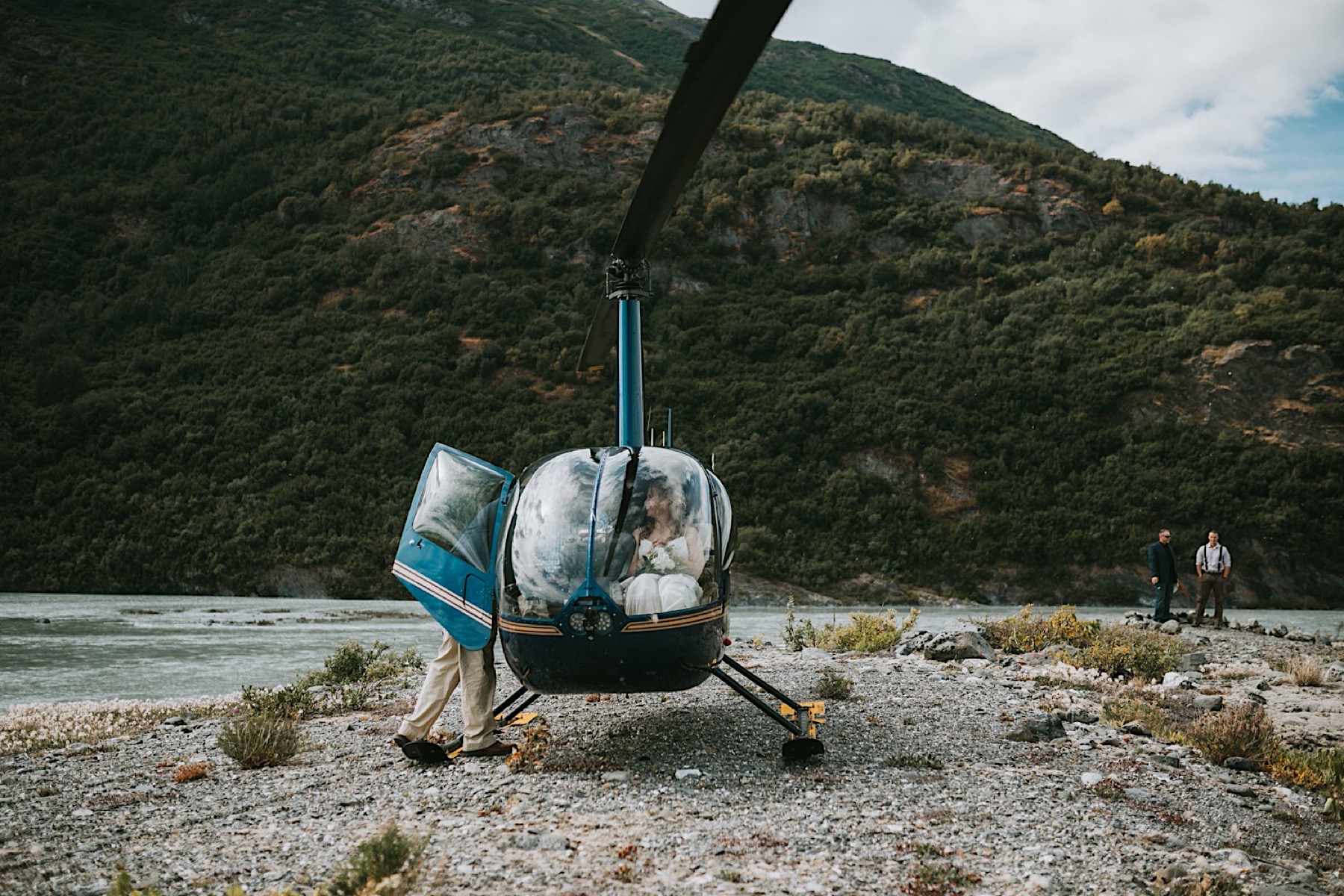 Bride about to get out of the helicopter for her alaska destination wedding