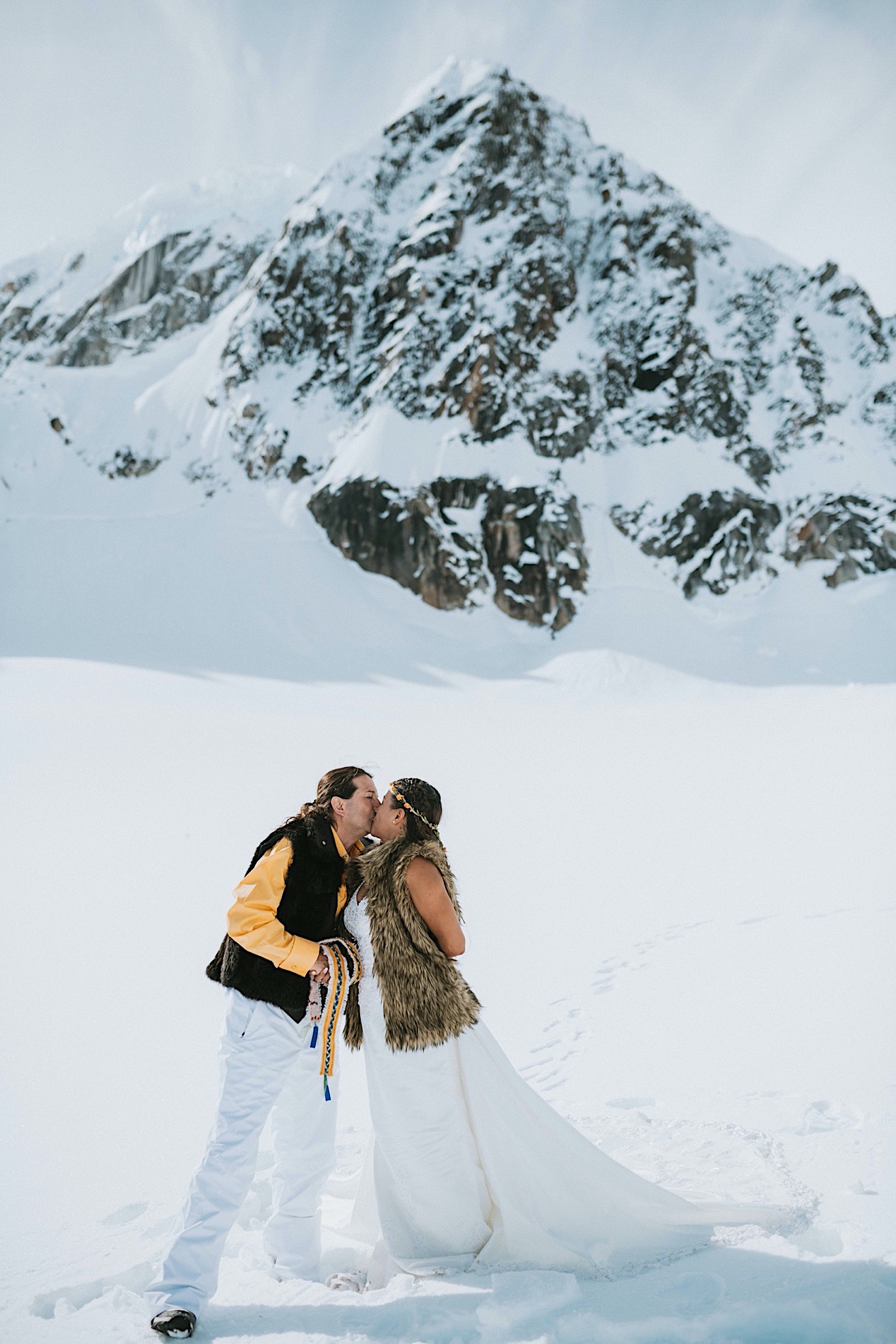 A couples first kiss after their wedding on a glacier