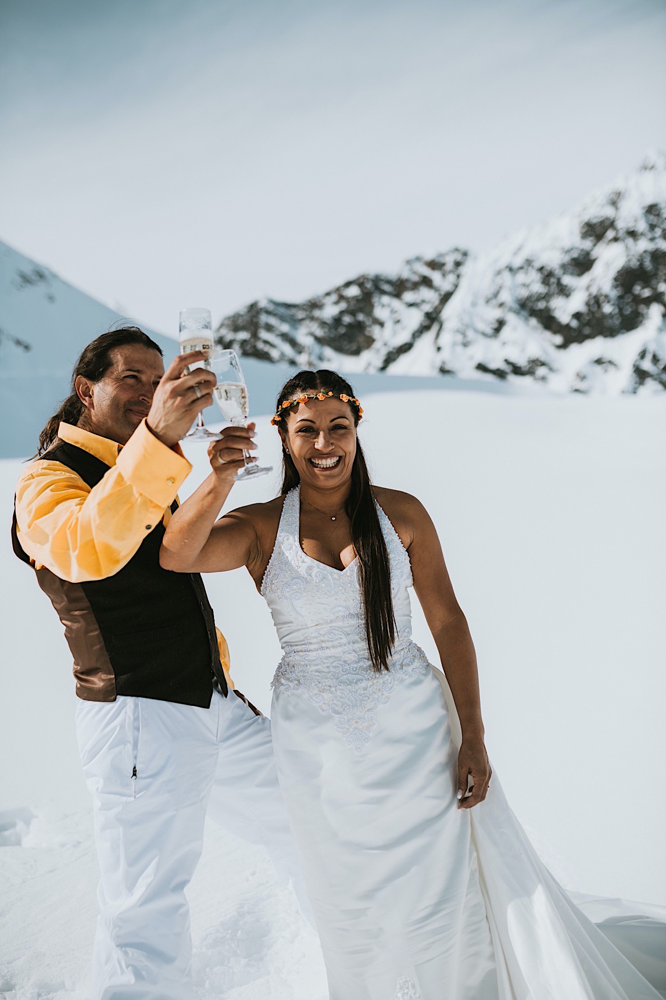 Bride and groom cheersing their champagne after their alaska glacier wedding