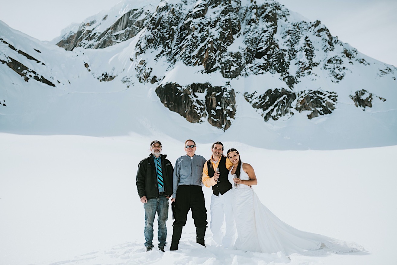 Group photo of the bride and groom with their officiant Celtic Ministries and their pilot from Sheldon Air Services on Ruth glacier