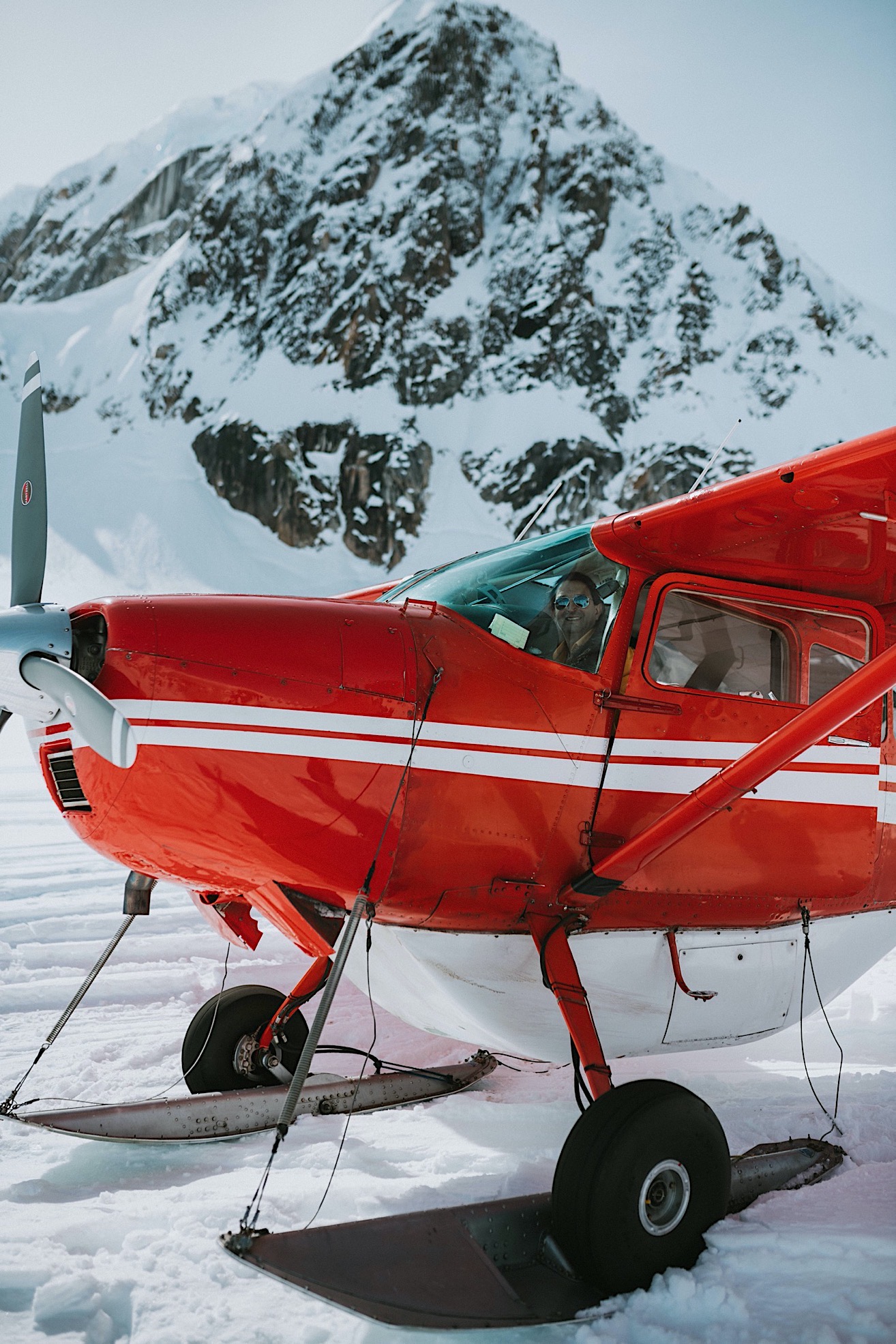 Photo of a groom sitting inside a red plane