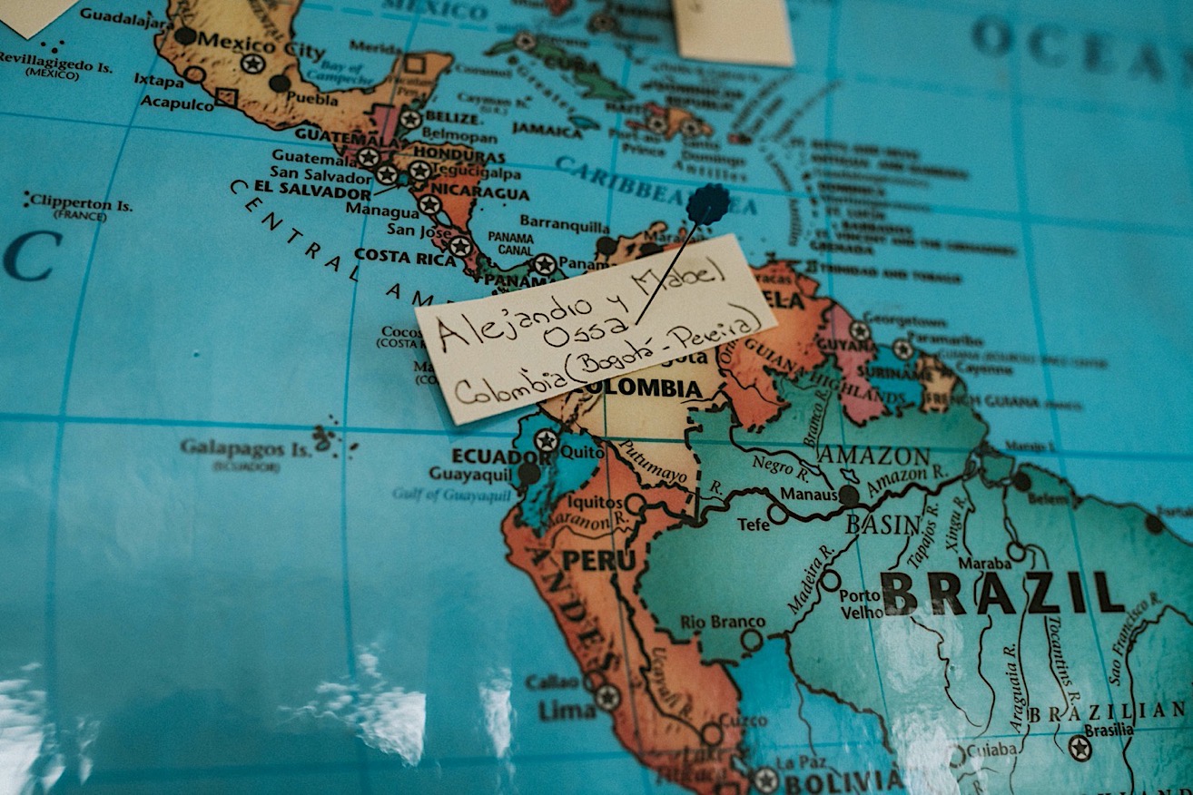 Photo of the bride and grooms name pinned to the map of the world on top of Colombia