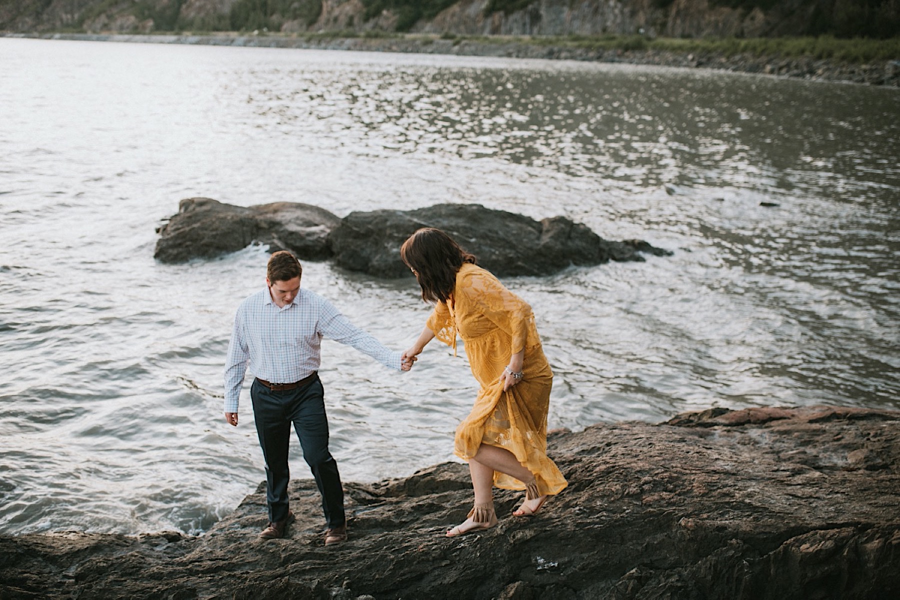 Couple walking down rocks at Beluga Point during engagement session