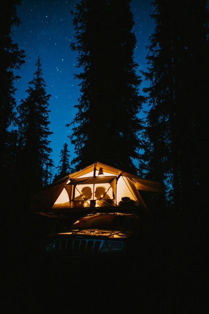 A couple elopes in a tent in an Alaskan forest at night.