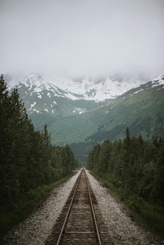 A train track leading to a snow-covered mountain, perfect for an Alaska elopement.