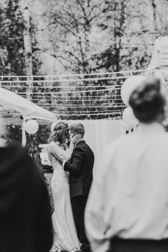 Black and white photo of bride and groom sharing first dance in backyard reception during Micro Wedding