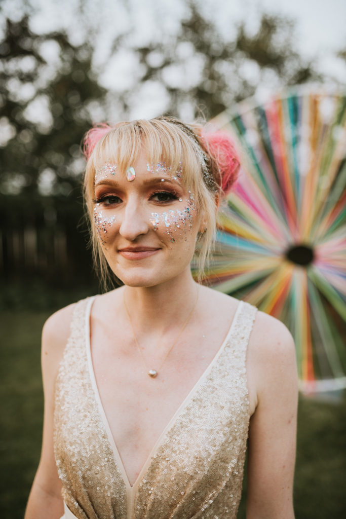 Coachella inspired bride with glitter on her face and pink space buns