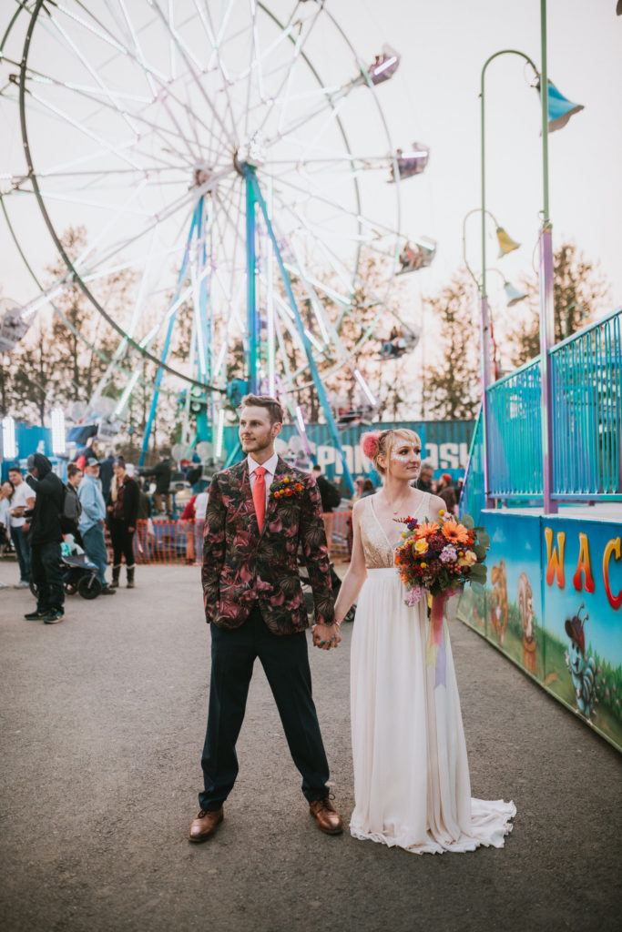 Wedding photo in front of a ferris wheel where couple is doing the hipster pose